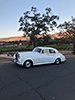 white Rolls-Royce with sunset and green trees